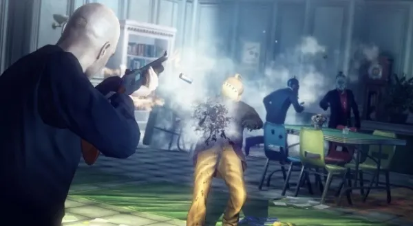 A bald man in a black suit is firing a gun at an explosion, with smoke and debris flying around. The scene takes place in a room with colorful chairs and tables, and there are other people reacting to the explosion. The lighting suggests it's daytime.