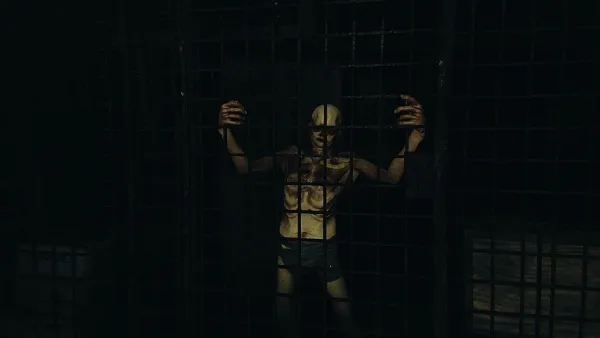 A muscular man with a bald head and tattoos on his chest stands behind bars, gripping them tightly. The dim lighting casts shadows across his intense expression, creating an atmosphere of tension and confinement. He is wearing dark shorts, and the background suggests a gritty urban setting.