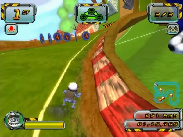 A screenshot from a video game featuring a character in motion, with a speedometer showing 251 km/h and a timer at 01:19.769. The scene includes a grassy track with red and white striped barriers, power-ups, and a mini-map in the top right corner. The player's progress is indicated by "1st" on the top left, and there are three lives shown as "3/3". The character has a blue body and a white head, resembling a robot or alien.