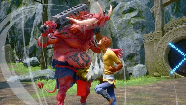 A red-skinned, horned creature with a large hammer is engaged in combat with a human character dressed in yellow and blue. The scene takes place outdoors near a stone structure with a glowing blue portal or door. The background features lush greenery and rocky terrain.