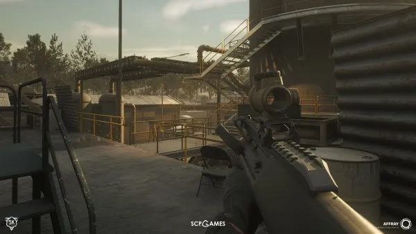 A first-person perspective of a video game character holding a rifle with a scope, standing on an industrial rooftop. The environment includes metal railings, barrels, and pipes, with a hazy sky in the background. The scene is set during daylight hours, possibly late afternoon or early evening. The overall atmosphere is tense and atmospheric.